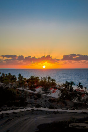 wonderful rising sun in the morning in front of the coast of the canary island Fuerteventura, in the foreground you can see white vacation houses of a vacation resortの写真素材