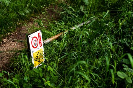 These warning sign are on a path leading through a wood to local fishing pond. They warn of overhead power lines.の写真素材