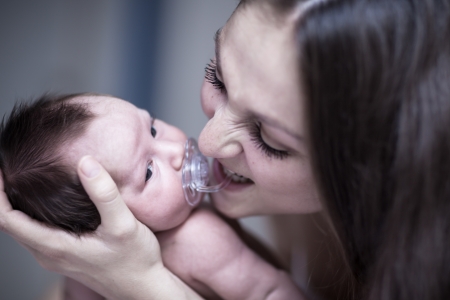 Newborn with dummy and mum
