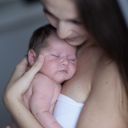 Sleeping newborn with his mumの写真素材