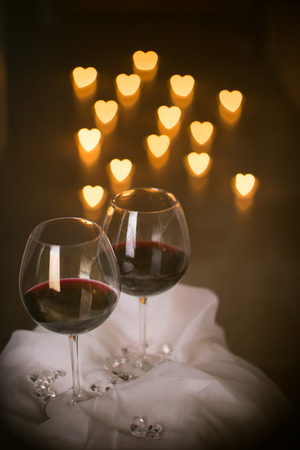 heart shaped candle lights with wine glassesの写真素材