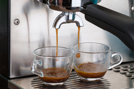 process of making two espresso shots using espresso machineの写真素材
