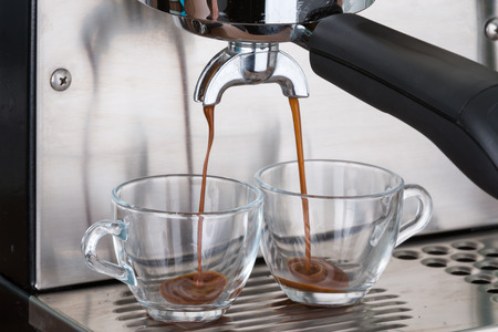 process of making two espresso shots using espresso machineの写真素材