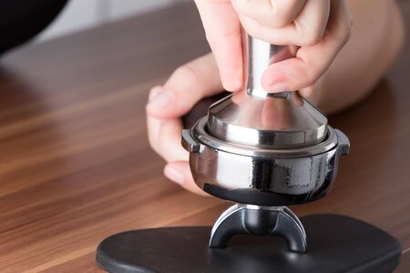 Process of tamping the coffee for espresso preparationの写真素材