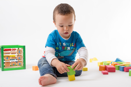 Small boy is playing with colorful cubesの写真素材