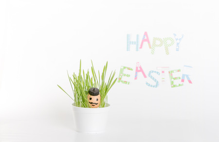 Easter decoration made of grass and egg-shell face with hairの写真素材