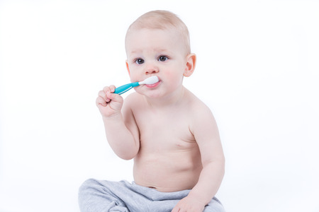Small baby is training eating with plastic spoonの写真素材