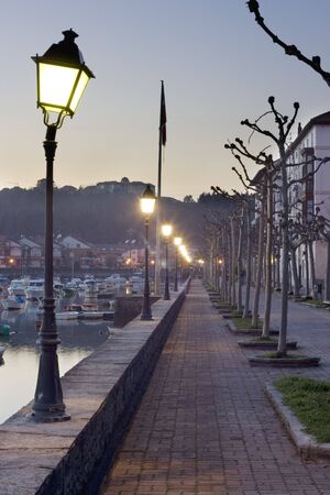 image of a long cold street with a line of lamppostの写真素材