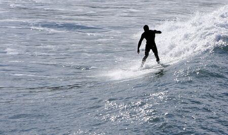 a man riding a wave with his surfing boardの写真素材