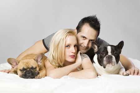 young sexy man and a woman with two funny french bulldogsの写真素材