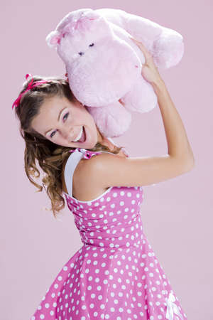 a beautiful inocent pin-up girl over a pink backgroundの写真素材