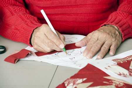 A quilter marks a paper pieced foundation layout for accuracy の写真素材