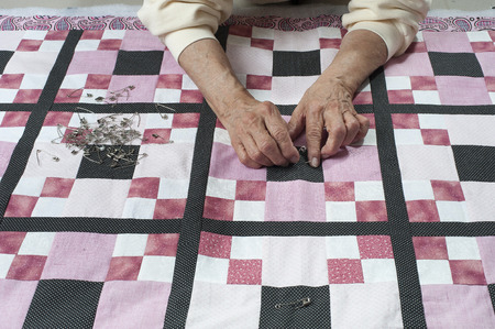 Pinning quilt top to the back in preparation for quilting.