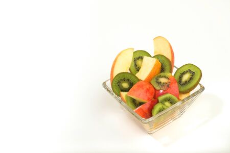 A small glass bowl filled with a fresh variety of fruit.の写真素材