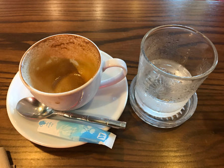 Drink a cup of coffee and cold water on the table.の写真素材