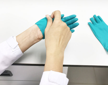 Scientists are removing green synthetic rubber gloves through laboratory sterilization.
