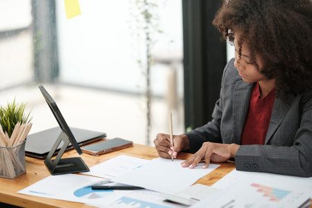 American African Woman working in the office with computer phone and Tablet.の写真素材