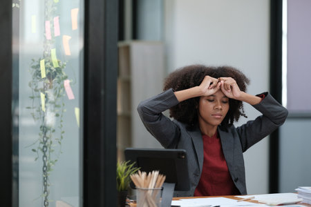 American African Woman working in the office with computer phone and Tablet.の写真素材