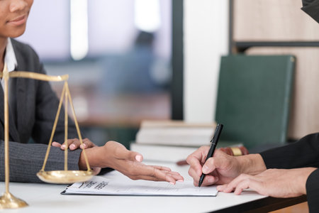 Lawyer office. Statue of Justice with scales and lawyer working on a laptop. Legal law, advice and justice concept.の写真素材