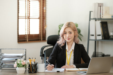 Close up on laptop in office, Asian happy beautiful businesswoman in formal suit work in workplace....