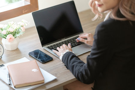 Close up on laptop in office, Asian happy beautiful businesswoman in formal suit work in workplace. Attractive female employee office worker smile.の写真素材