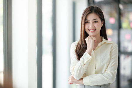 Charming Asian woman with a smile looking to the camera in the office.の写真素材