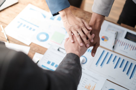 Close-up of business partners making pile of hands at meeting.