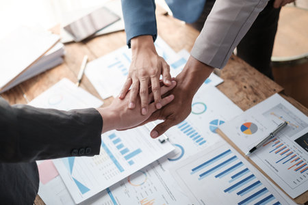 Close-up of business partners making pile of hands at meeting.