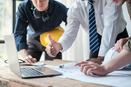 Close up group engineers success the planning about project in a computer. Brainstorming of engineers. Construction engineering conceptual. Three architects in office and discussing project.の写真素材