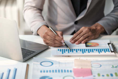Close up young man with calculator counting making notes at home, hand is writing in a notebook. Savings finances conceptの写真素材
