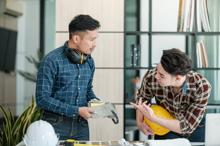 Two engineers discussion and planning about project. Brainstorming of engineers. Construction engineering conceptual. Three architects in office and discussing project.の写真素材