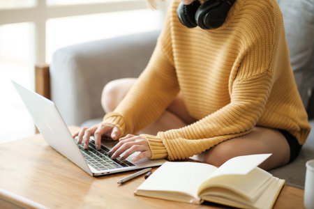 Beautiful asian woman online learning with laptop in living room.の写真素材