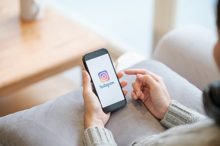 CHIANG MAI, THAILAND - Apr. 19,2023 : Woman holding iPhone 14 Pro Max with Instagram application on the screen. Instagram is a popular online social networking service.のeditorial素材