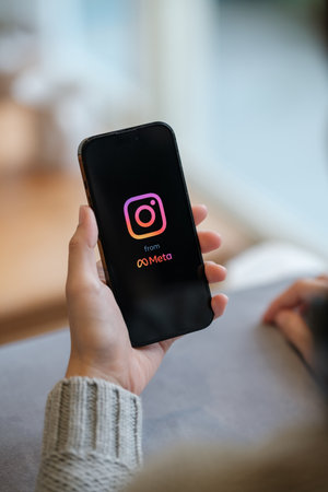 CHIANG MAI, THAILAND - Apr. 19,2023 : Woman holding iPhone 14 Pro Max with Instagram application on the screen. Instagram is a popular online social networking service.のeditorial素材