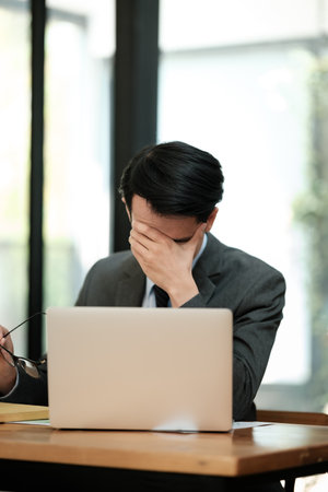 Businessmen feel stressed and tired sitting at his office with a laptop,mobbing conceptの写真素材