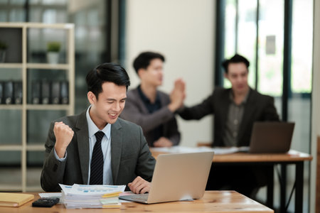 Young handsome asian businessman success working in the office looking to a computer.の写真素材