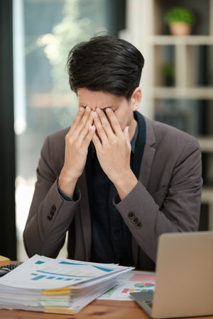 Businessmen feel stressed and tired sitting at his office with a laptop,mobbing conceptの写真素材