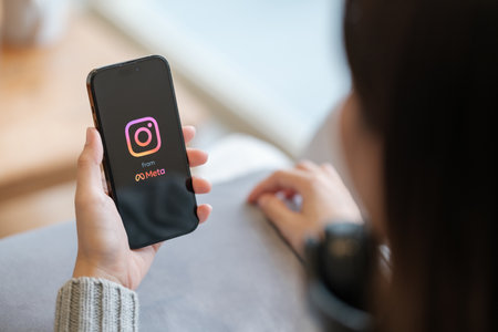 CHIANG MAI, THAILAND - Apr. 19,2023 : Woman holding iPhone 14 Pro Max with Instagram application on the screen. Instagram is a popular online social networking service.のeditorial素材