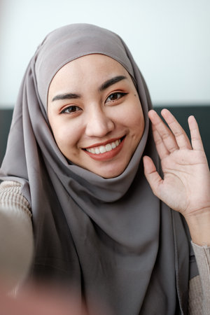 A Beautiful asian woman in hijab talks on video call, online meeting with colleagues and clients,...
