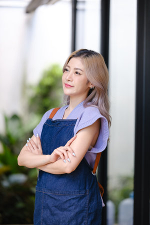 Startup successful small business owner sme beauty girl stand with tablet smartphone in coffee shop restaurant. Portrait of asian tan woman barista cafe owner. SME entrepreneur seller business conceptの写真素材