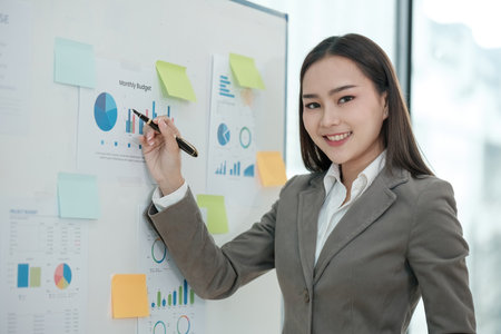 A woman is drawing on a white board with a marker