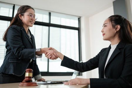 Two women shaking hands in a business settingの写真素材