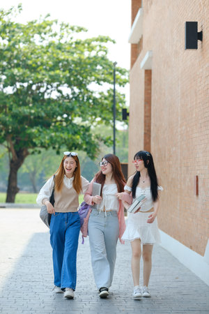 Three women walking down a brick street, one of them wearing a white dressの写真素材