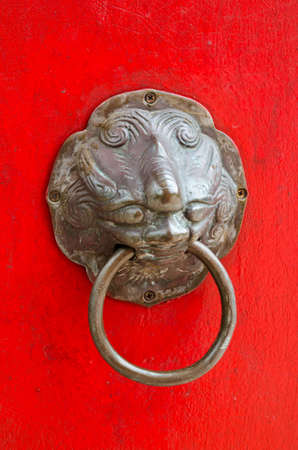 Old handle on red temple door,Thailandの写真素材