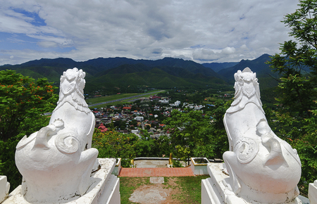Back view of two white lions statue at Wat Phra That Doi Kong Mu with aerial city view of Mae Hong Son, Northern Thailandの写真素材