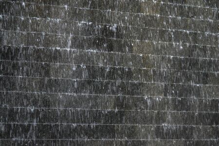 small garden waterfall on the wall of the Buildingの写真素材