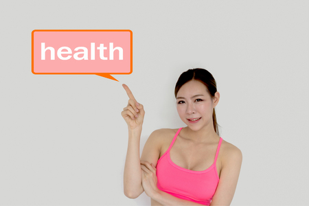 Young woman exercising is pointing at the sign.の写真素材