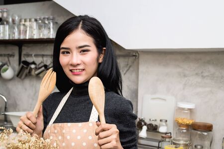 Beautiful woman chef Smile happily in the cookingの写真素材