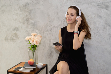 Beautiful young woman enjoying music at home.の写真素材