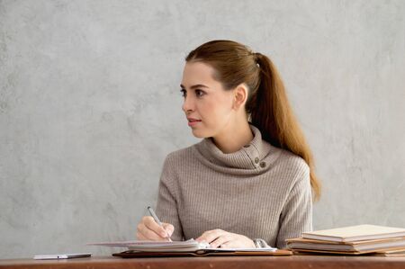 Beautiful girl is working happily on the desk.の写真素材